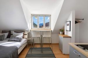 a small bedroom with a bed and two chairs at Sommavilla Apartments in Silandro