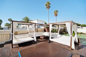 a porch with white beds on a deck at Carolina Beach House in Chiclana de la Frontera