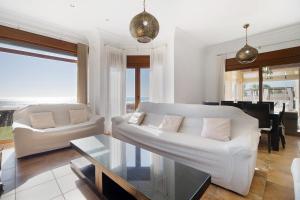a living room with a white couch and a table at Carolina Beach House in Chiclana de la Frontera