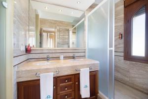 a bathroom with a sink and a large mirror at Carolina Beach House in Chiclana de la Frontera +36 photos