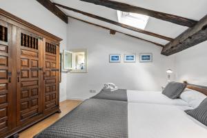 a bedroom with two beds and a wooden door at Apartamento 2 Casa Las Indianas in Selores