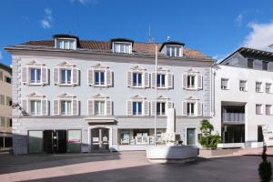 a large white building with a fountain in front of it at Sommavilla Apartments in Silandro