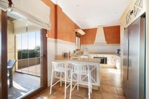 a kitchen with white chairs and a kitchen island at Carolina Beach House in Chiclana de la Frontera
