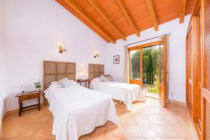 two beds in a room with a window at Garballo in Betlem