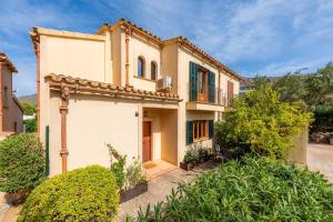 a large house with a balcony and bushes at Garballo in Betlem