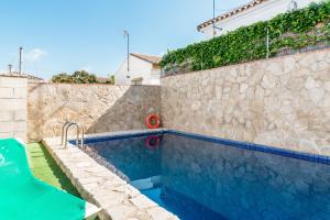 a swimming pool in front of a house with a wall at Chalet Aragon Muñoz in Conil de la Frontera