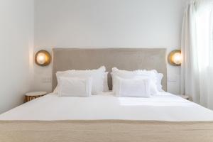 a white bed with white pillows in a bedroom at Casa Ancla in Tías