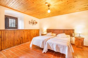 two beds in a large room with wooden walls at Sant Grau ii in Navés +35 photos