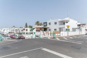 an empty parking lot with cars parked in front of buildings at Casa Ancla in Tías
