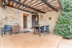 a patio with a table and chairs and a stone wall at Sant Grau ii in Navés