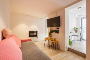 a living room with a couch and a tv at Dulce y acogedor in Vilanova i la Geltrú