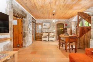 a living room with a wooden ceiling and a table at Sant Grau ii in Navés
