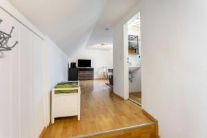 a kitchen and living room with white walls and wooden floors at Ferienwohnung Am Osttor in Warendorf
