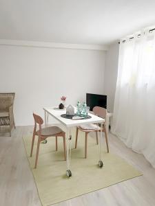 a dining room with a white table and two chairs at Ruhiges Apartment Münster Baumberge in Nottuln