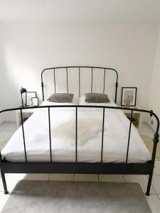 a black metal bed frame in a bedroom at Ruhiges Apartment Münster Baumberge in Nottuln