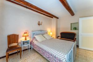 a bedroom with a bed and a chair at Gîte Chez Martha in Anduze