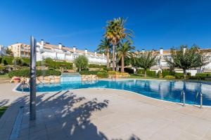 a swimming pool in a resort with palm trees and buildings at Fantàstic s'agaró in S'agaro