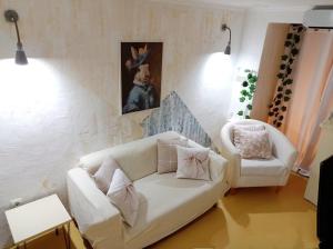 a living room with a white couch and a chair at Ca Les Nines 2 in Pinell de Bray