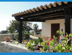 a wooden pergola in front of a house with flowers at Isola Di Favignana in Favignana