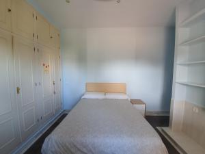 a small bedroom with a large bed and white cabinets at Finca Campo Viejo in Isla Cristina