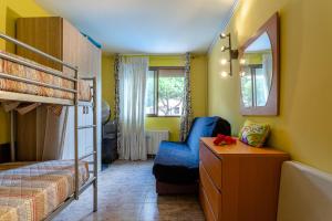 a bedroom with a bunk bed and a blue chair at Apartamento Costa Brava in Blanes