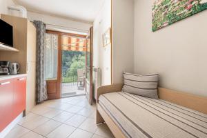 a small bedroom with a bed and a balcony at Residence Tatiana A3 in Tremosine Sul Garda +27 photos