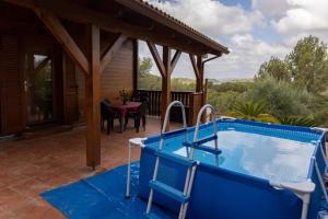 a pool on a patio with a table and a house at Casa de Madera en Calafell in Calafell