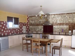 a kitchen with a wooden table and chairs at Clos Des Hogues - Chambres d'hôtes in Saint-Léonard +29 photos