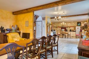 a dining room and living room with a table and chairs at Clos Des Hogues - Chambres d'hôtes in Saint-Léonard