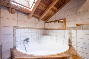 a bath tub in a bathroom with a window at Chalet La Grange des Flocons in Valloire +29 photos