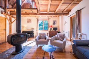 a living room with a fireplace and a tv at Chalet La Grange des Flocons in Valloire