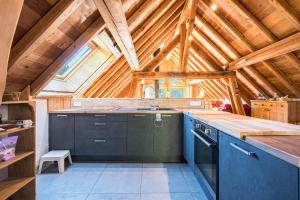a kitchen with blue cabinets and a wooden ceiling at Chalet La Grange des Flocons in Valloire