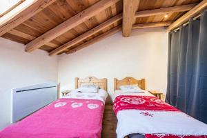 two beds sitting next to each other in a room at Chalet La Grange des Flocons in Valloire