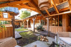 an open porch of a wooden house with wooden beams at Villa Bayani in Lacanau