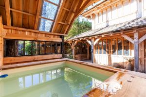 an indoor swimming pool in a wooden house with a building at Villa Bayani in Lacanau