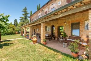 a brick building with a patio with a table and chairs at Agriturismo Podere Marroneto in Monticiano