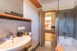 a bathroom with a sink and a shower and a tub at Alpen Chalet Alte Talstation in Lenggries