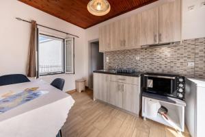 a kitchen with a table and a microwave in a room at Grenta Country House in Corfu