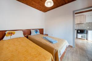 two beds in a room with white walls at Grenta Country House in Corfu