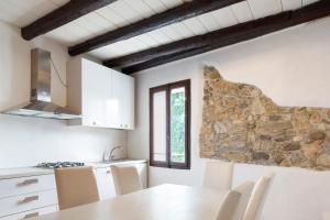 a kitchen with a table and a stone wall at Villa Bivai in Bivai