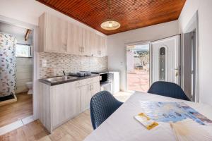 a kitchen with a table and chairs and a kitchen with a sink at Grenta Country House in Corfu