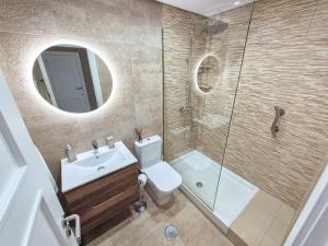 a bathroom with a toilet and a sink and a shower at Townhouse overlooking golf course in Las Armeras +30 photos