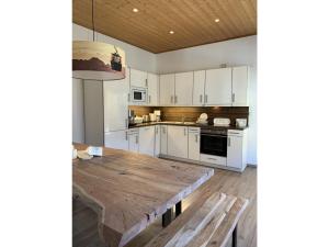a kitchen with a wooden table and white cabinets at Ferienwohnung Max 2 in Garmisch-Partenkirchen