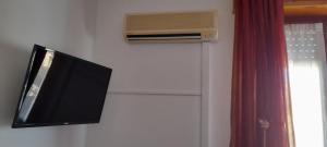 a television and an air conditioner on a wall at B e B Beglia Alguer in Alghero