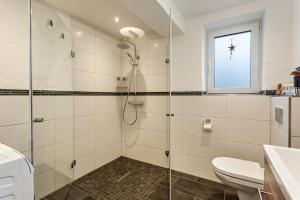 a bathroom with a shower and a toilet and a window at Ferienwohnung Kleine Auszeit in Schmallenberg +14 photos