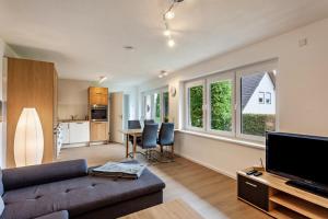 a living room with a couch and a table with chairs at Ferienwohnung Kleine Auszeit in Schmallenberg