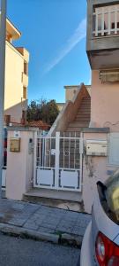 a white gate in front of a house with stairs at B e B Beglia Alguer in Alghero