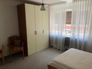 a bedroom with a white cabinet and a window at Ferienwohnung Innenstadt in Marktbreit