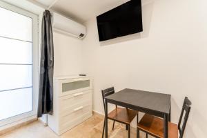a dining room with a table and a tv on the wall at Canto Cigalo Rdc 1 in Robion en Luberon