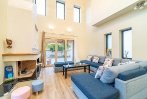 a living room with blue couches and a fireplace at The Mountain Villa in Aleimmatádes